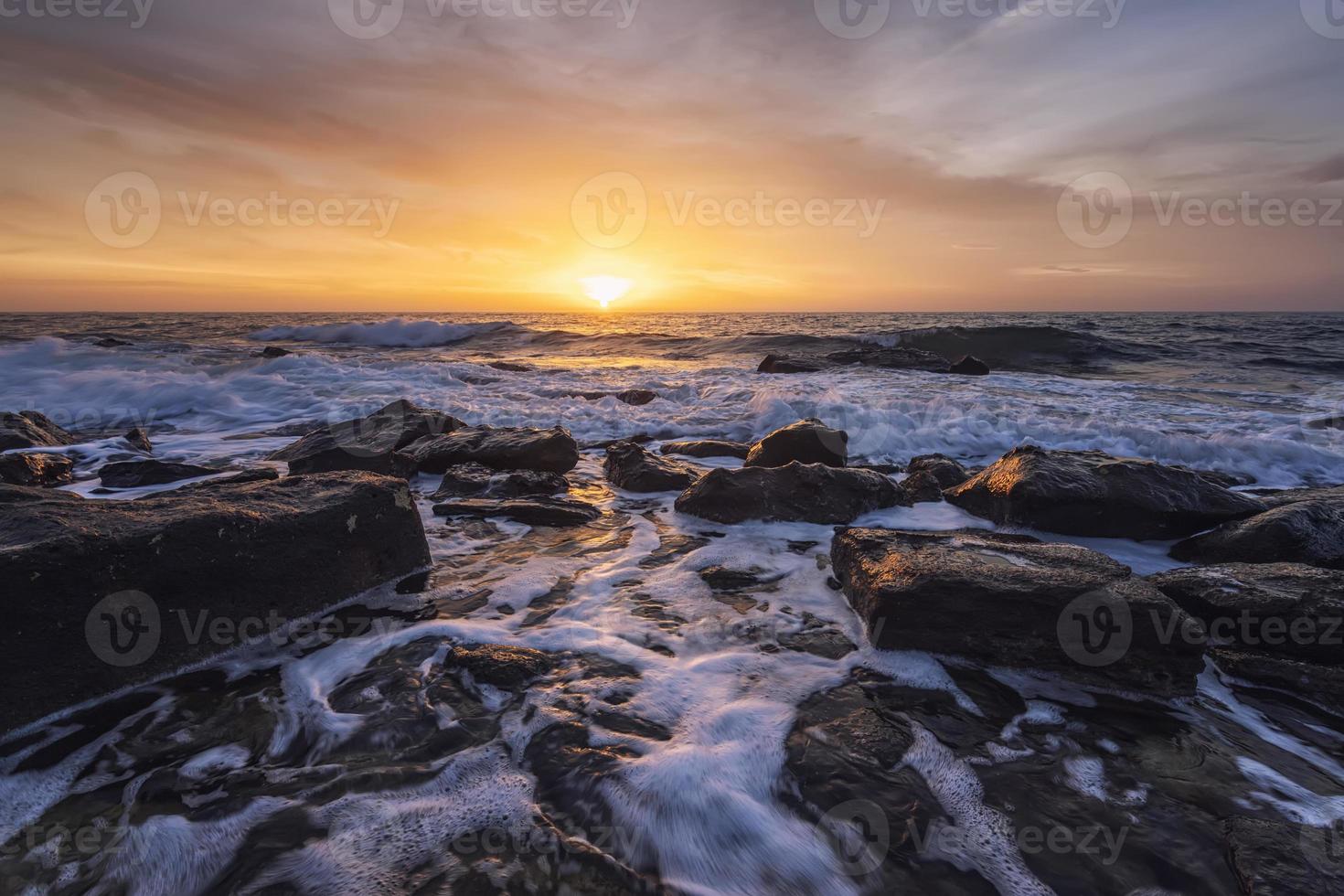 The stunning seascape with the colorful sky and water foam at the rocky coastline of the Black Sea photo