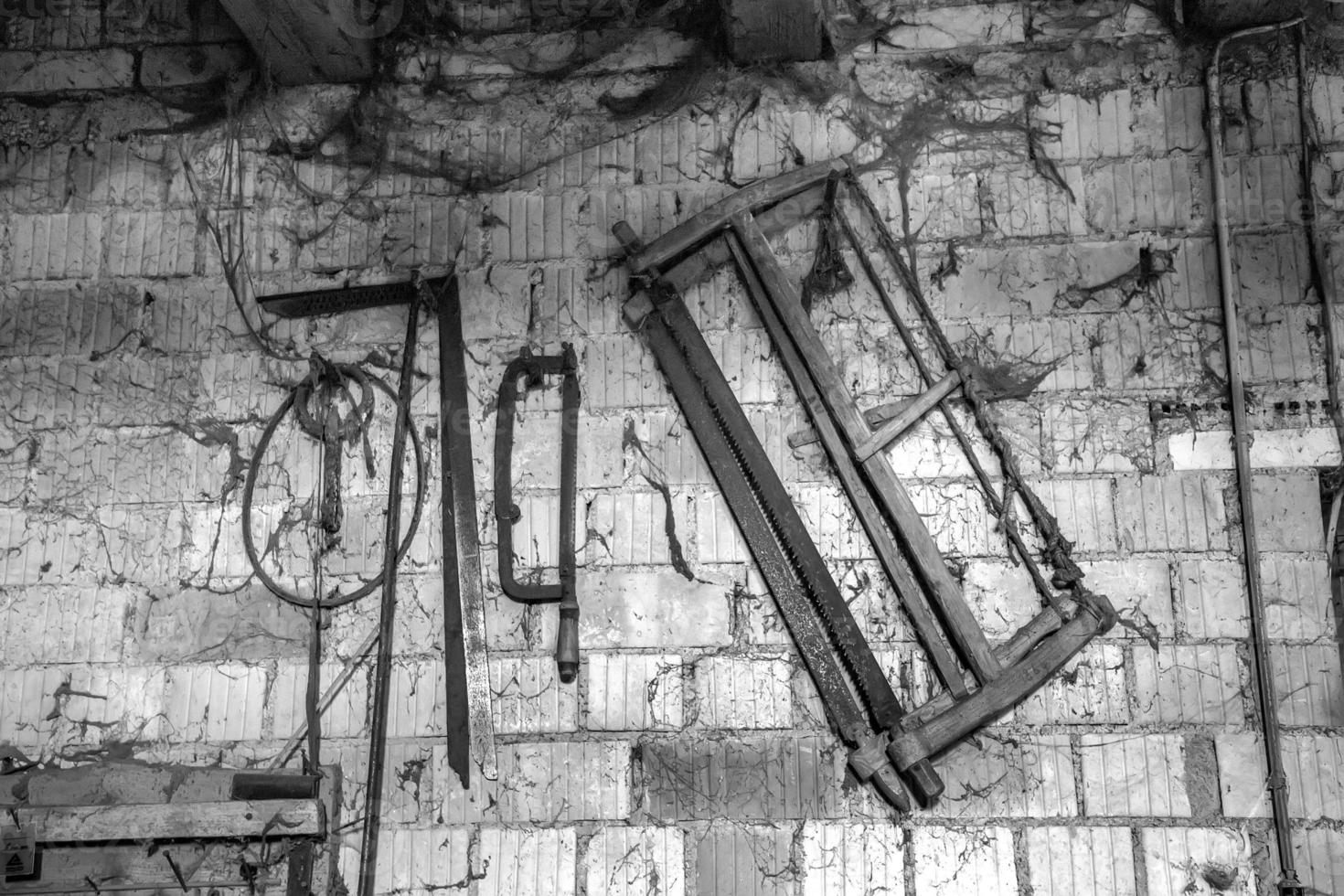 Old vintage carpenter tools on the wall. Black and white photo