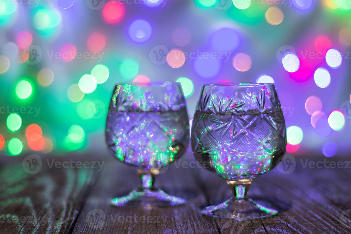 two glasses of champagne against bokeh lights background photo