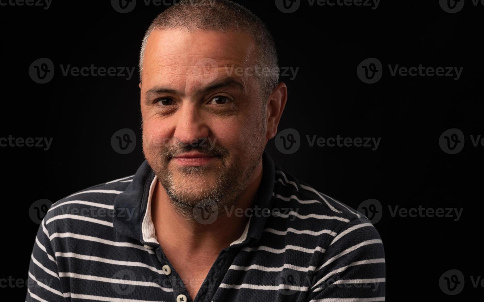 Man with one eyebrow raised on a black background with copy space photo
