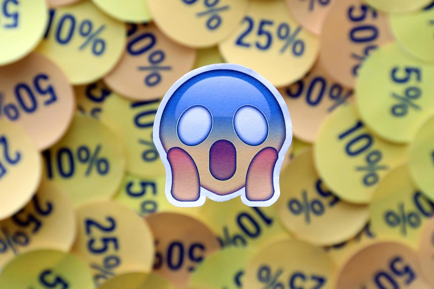 Ternopil, Ukraine - May 8, 2022 Shock emoji sticker on large amount of yellow stickers with percentage values for black friday or cyber monday photo