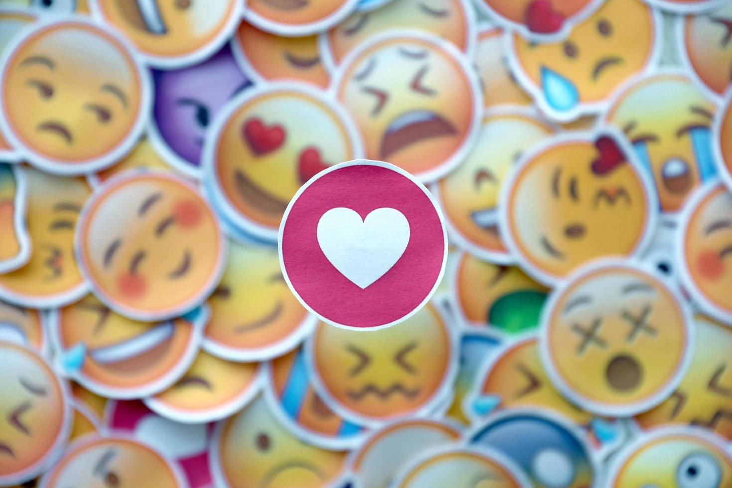 Ternopil, Ukraine - May 8, 2022 Large set of stickers with Emoji yellow faces. Red heart pictogram in focus photo