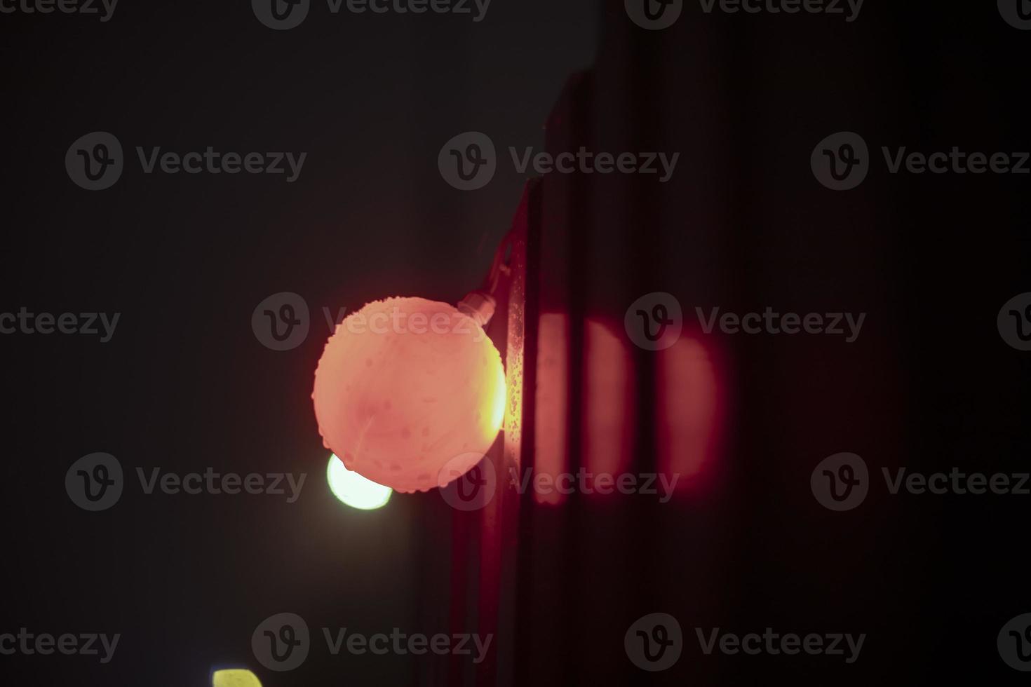 Red ball at construction site. Light on fence. photo