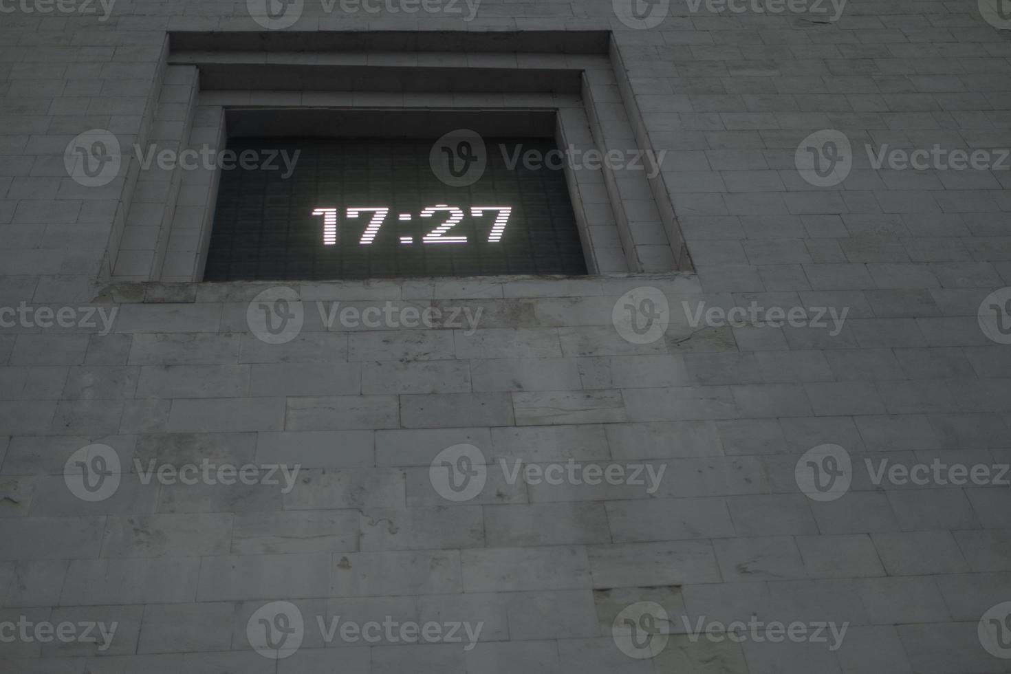 Time on clock board. Clock in wall. Time from electronic digits. photo