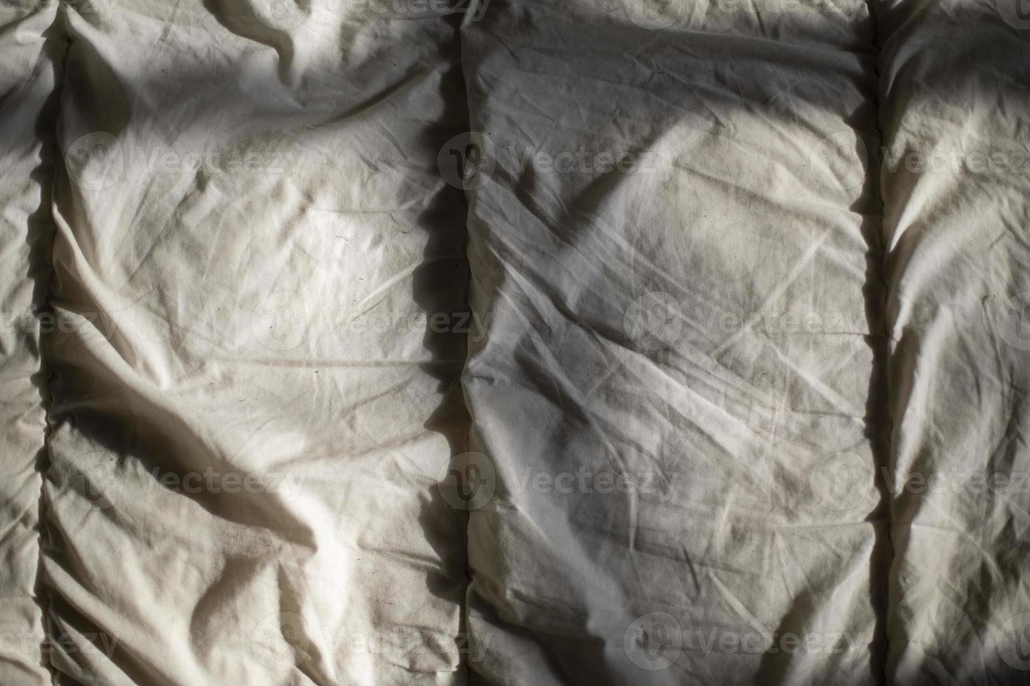 Matting sheet on bed. Texture of fabric in sunlight. photo