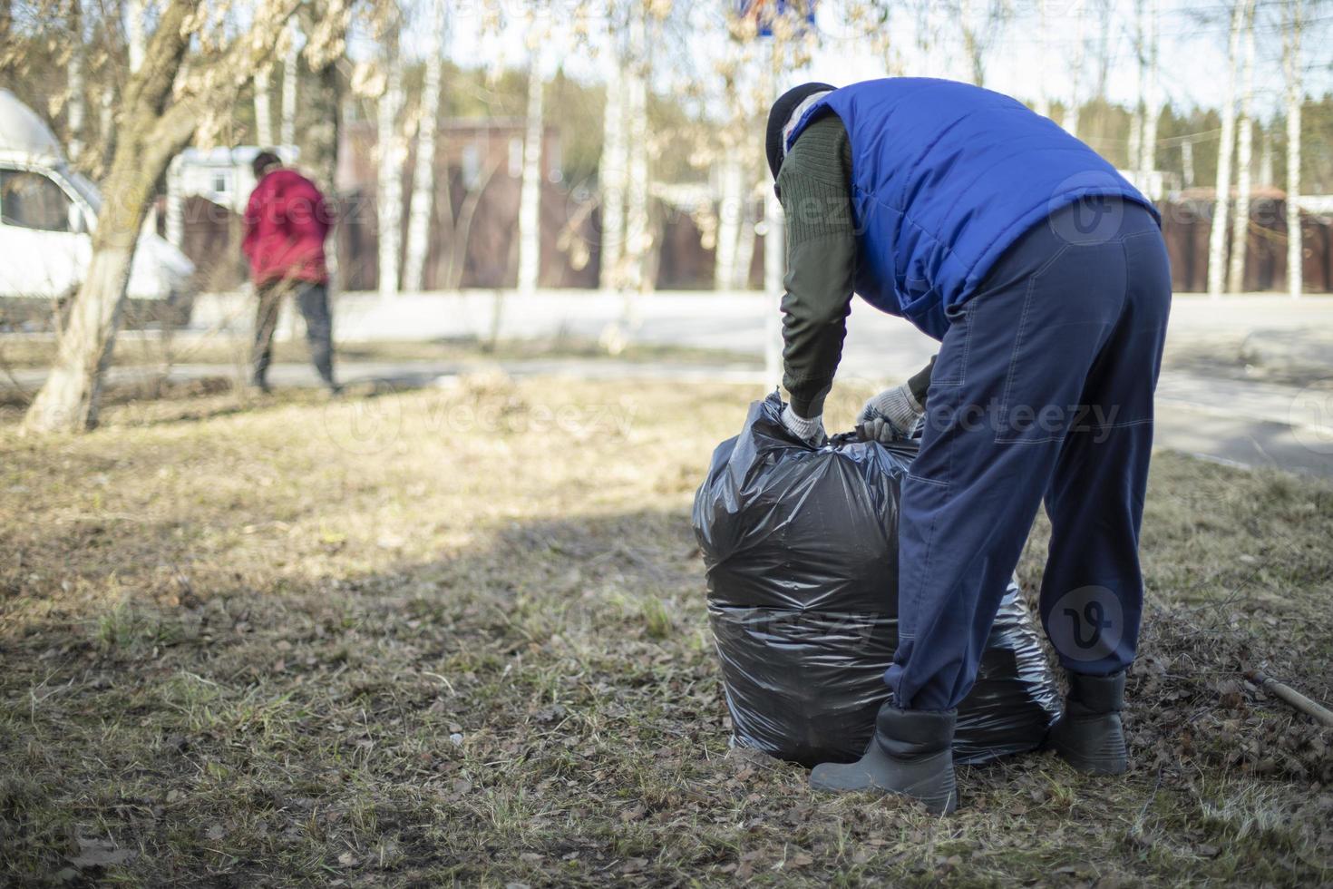 recogida de basura en bolsa. la gente limpia el patio. foto