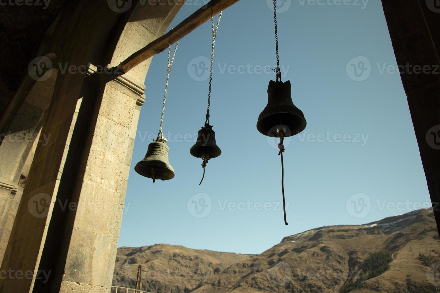 Bells against sky and mountains. Ropes for ringing. Bluebells of ancient world. photo