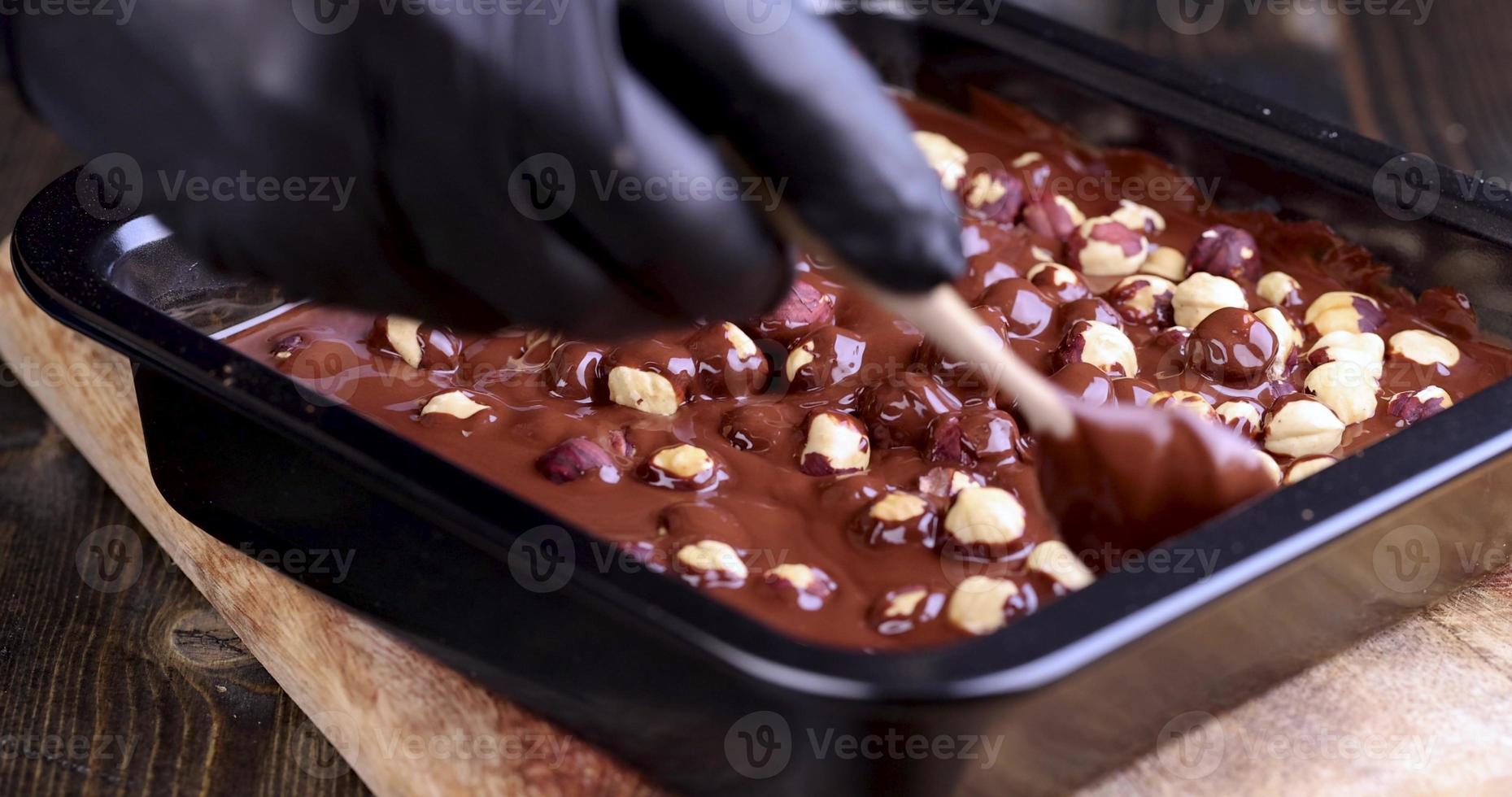 making chocolate from high-quality cocoa and cocoa butter with hazelnuts photo