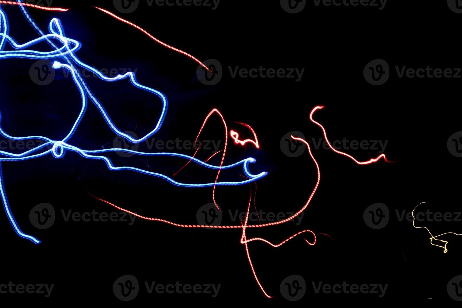 Chaotic lines in dark. Neon glow. Texture of bright lines. photo