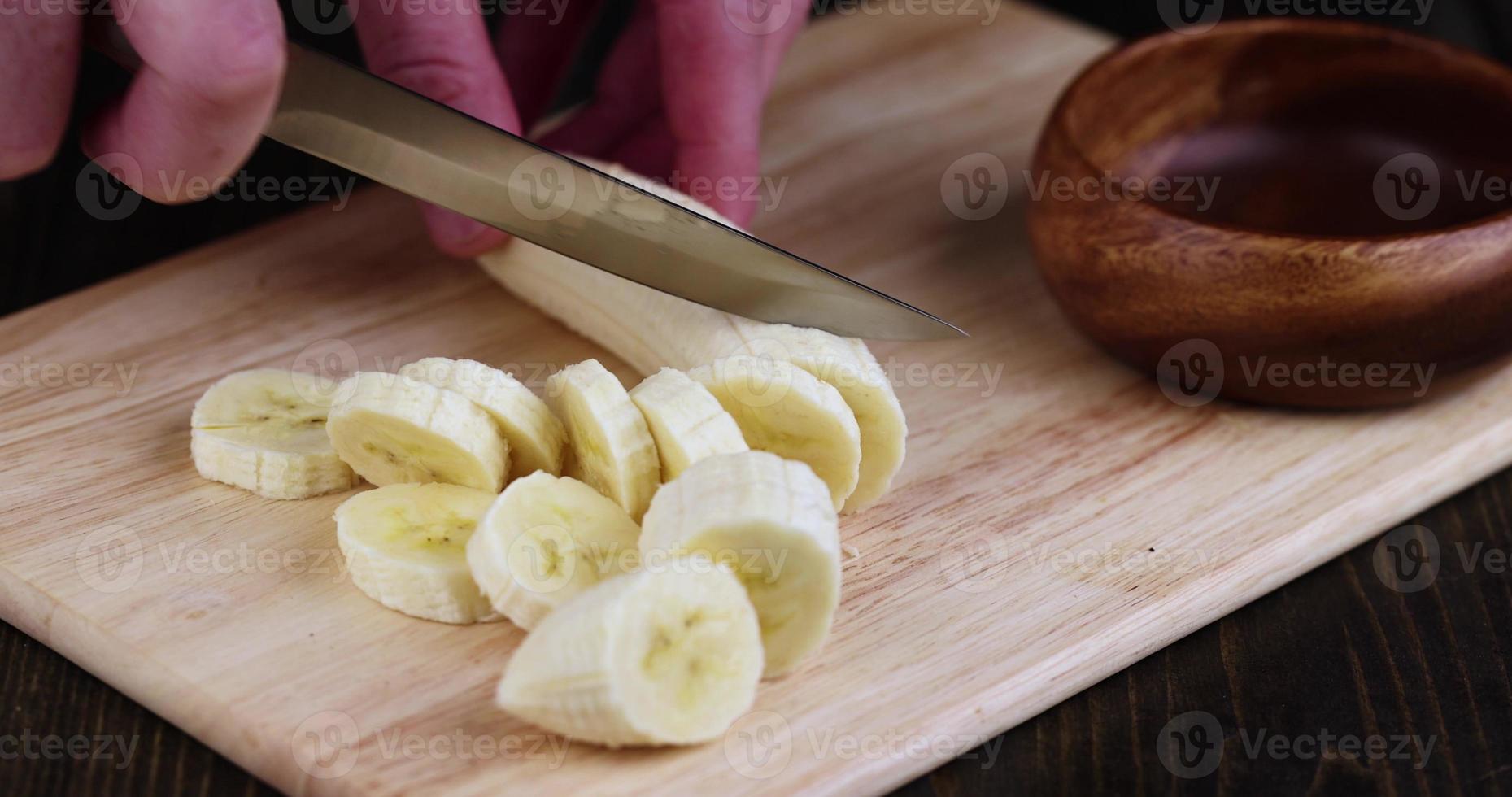cut a yellow ripe banana on a wooden board photo