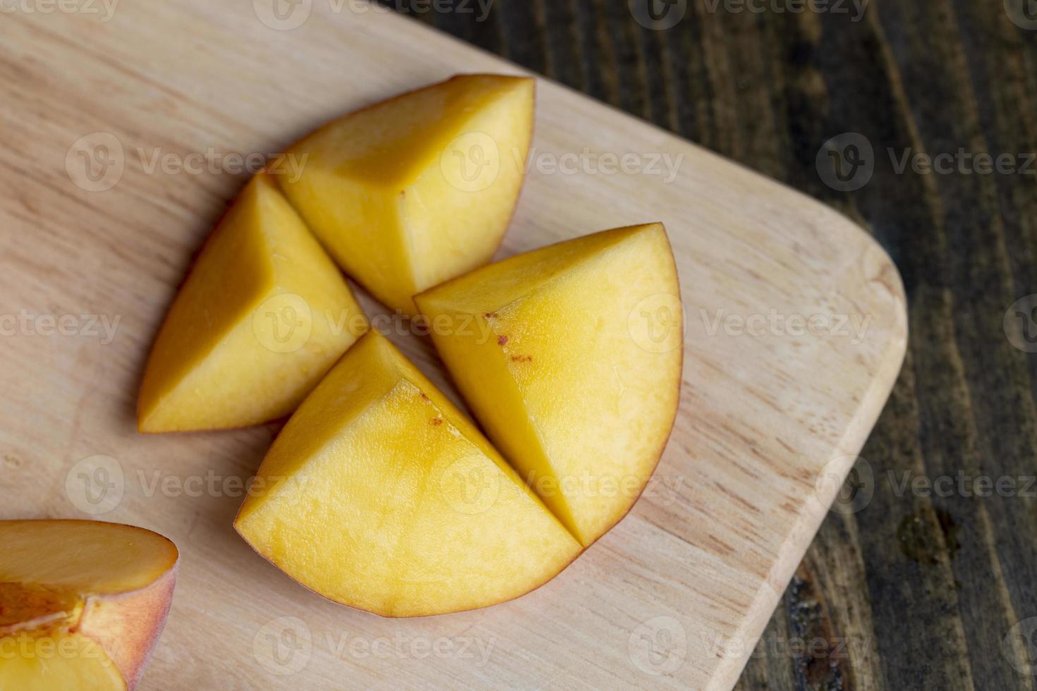 Ripe fresh peaches on a wooden table photo
