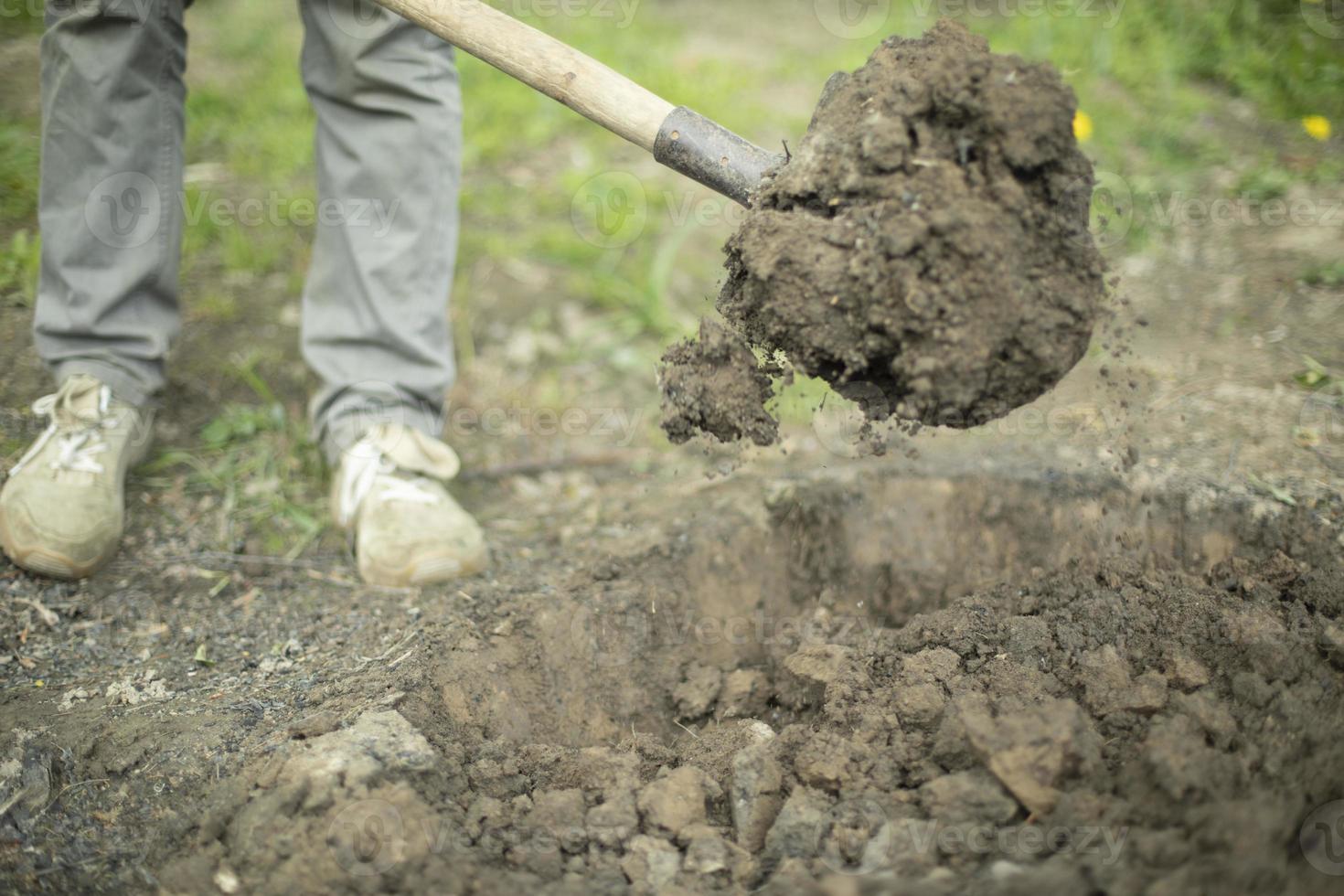 Guy is digging ground. Man with shovel. Details of rural life. Digging up soil. photo