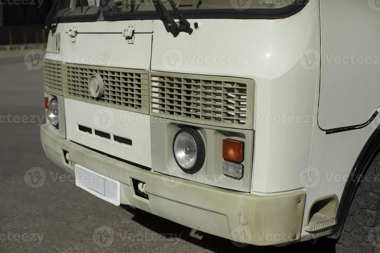 White bus in parking lot. Bus in city. Parking transport. Old car. photo