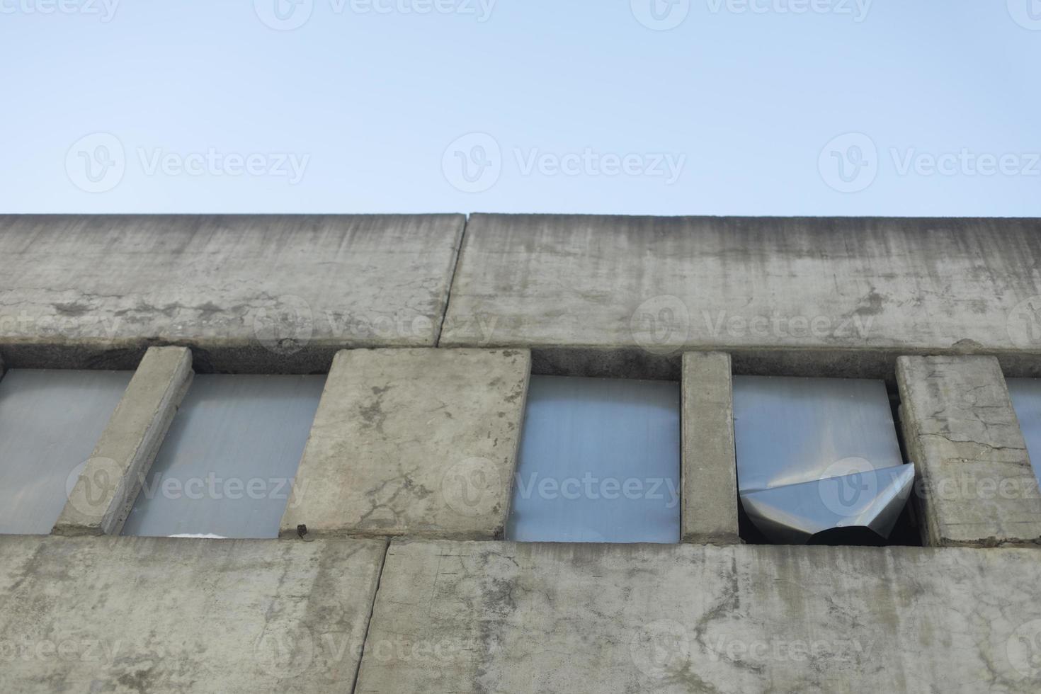 Windows closed with steel. Unfinished building. Abandoned house. Concrete structure. photo