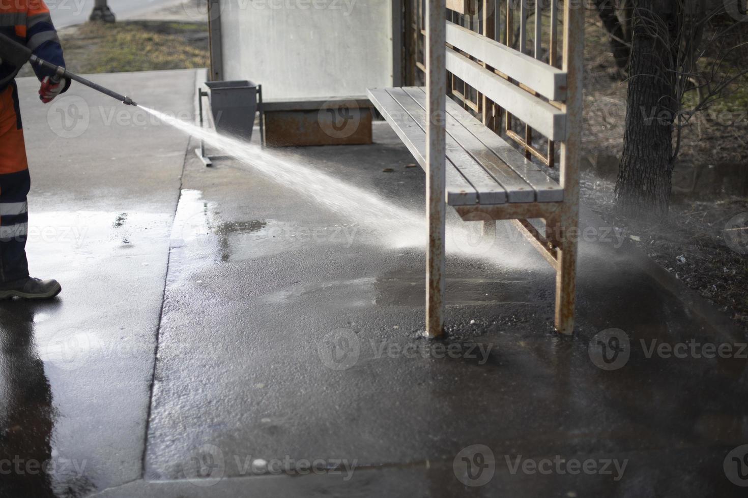 Cleaning on street. Washing bus stop in Russia. High pressure water flow. photo