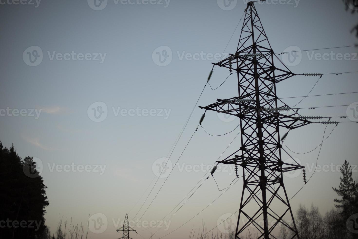 Power lines in evening. Tower of electricity against sky. photo