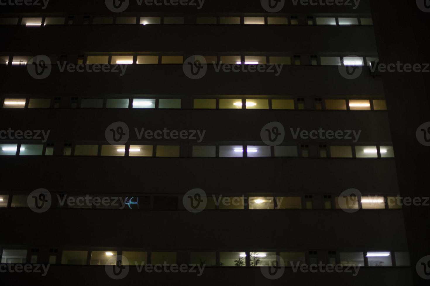 Windows in building at night. Light in house. photo