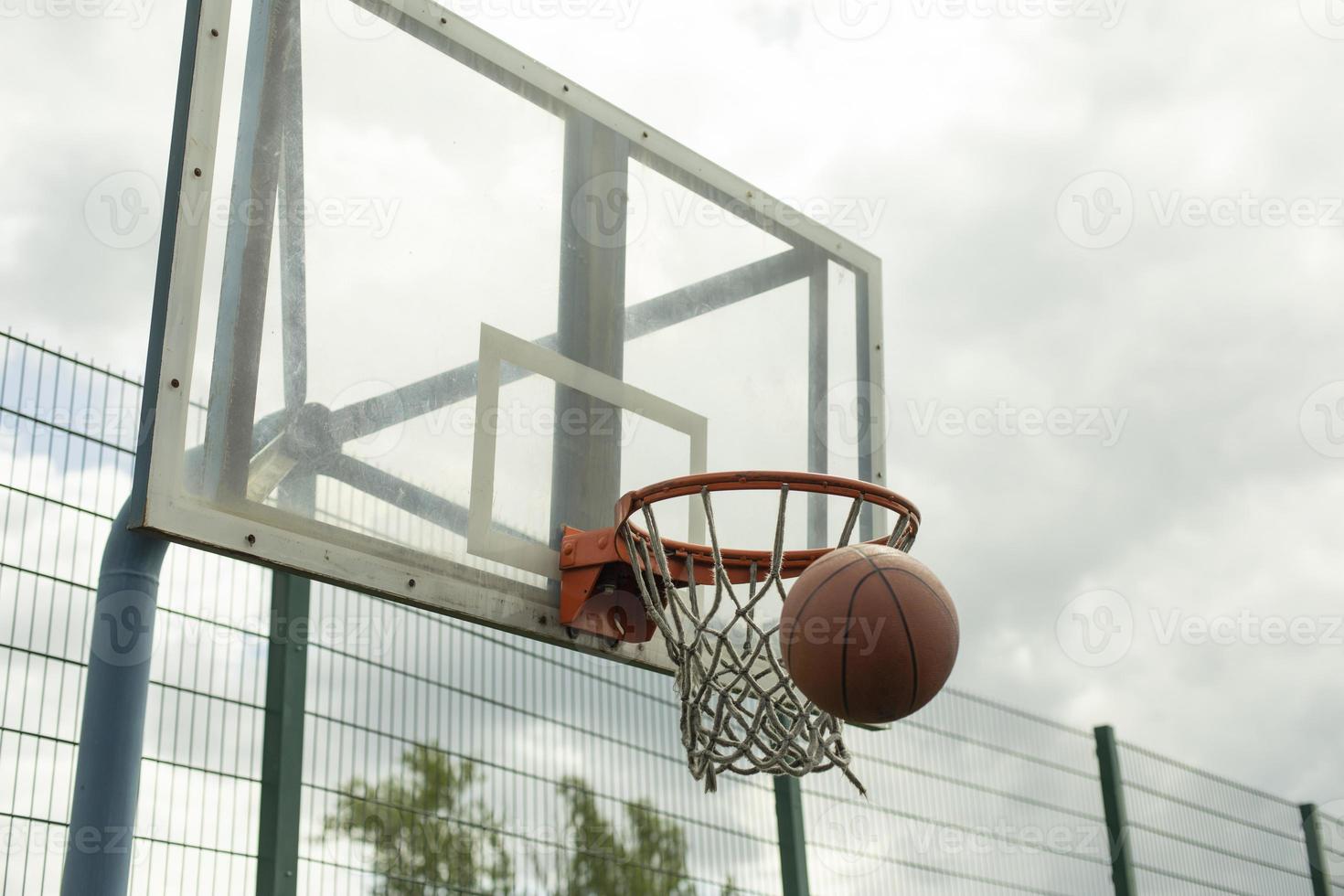 Throwing ball into hoop. Basketball flies into net. Basketball details. photo