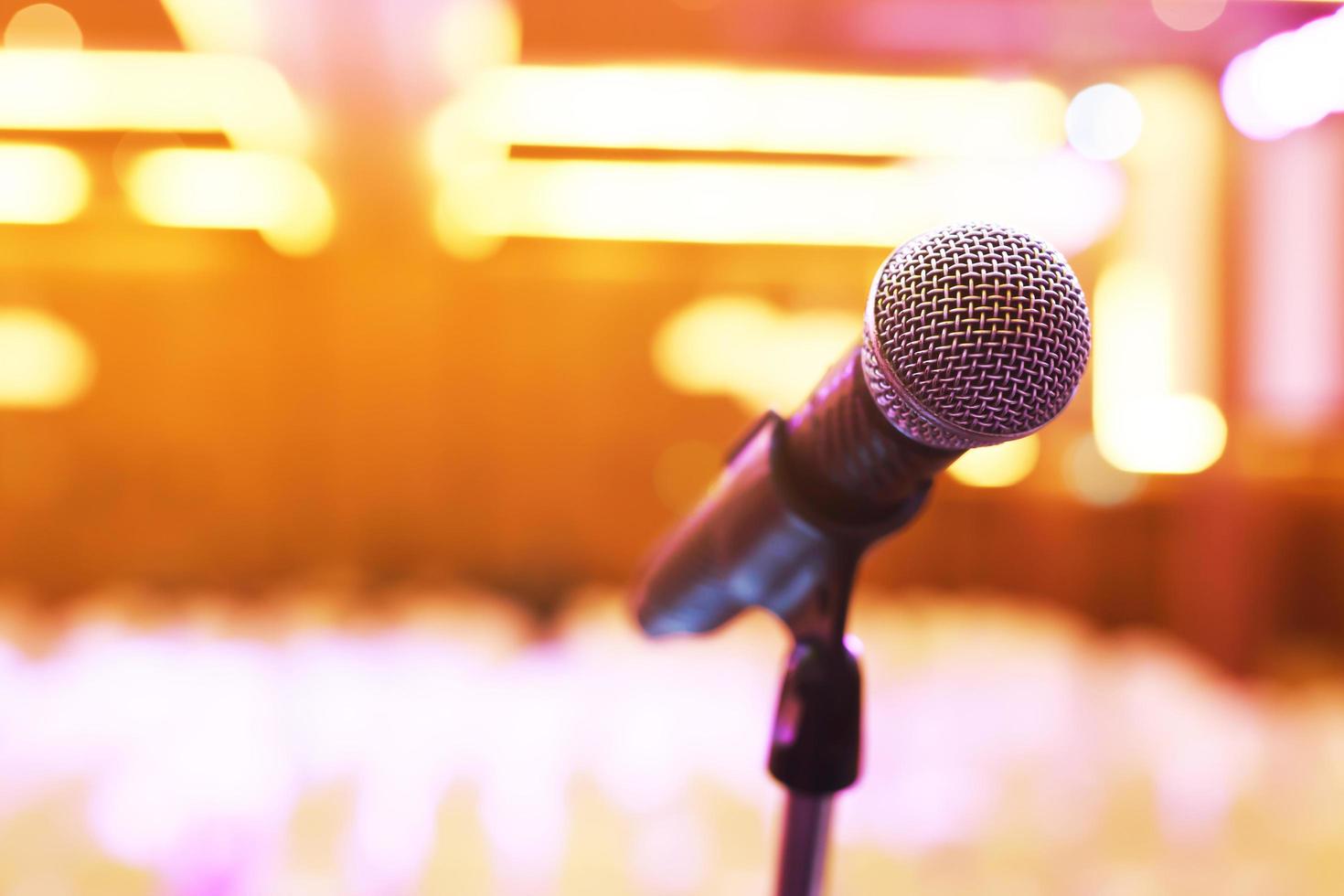 primer plano del micrófono en la iluminación del escenario en la sala de conciertos o sala de conferencias. copie la pancarta del espacio. enfoque suave. foto