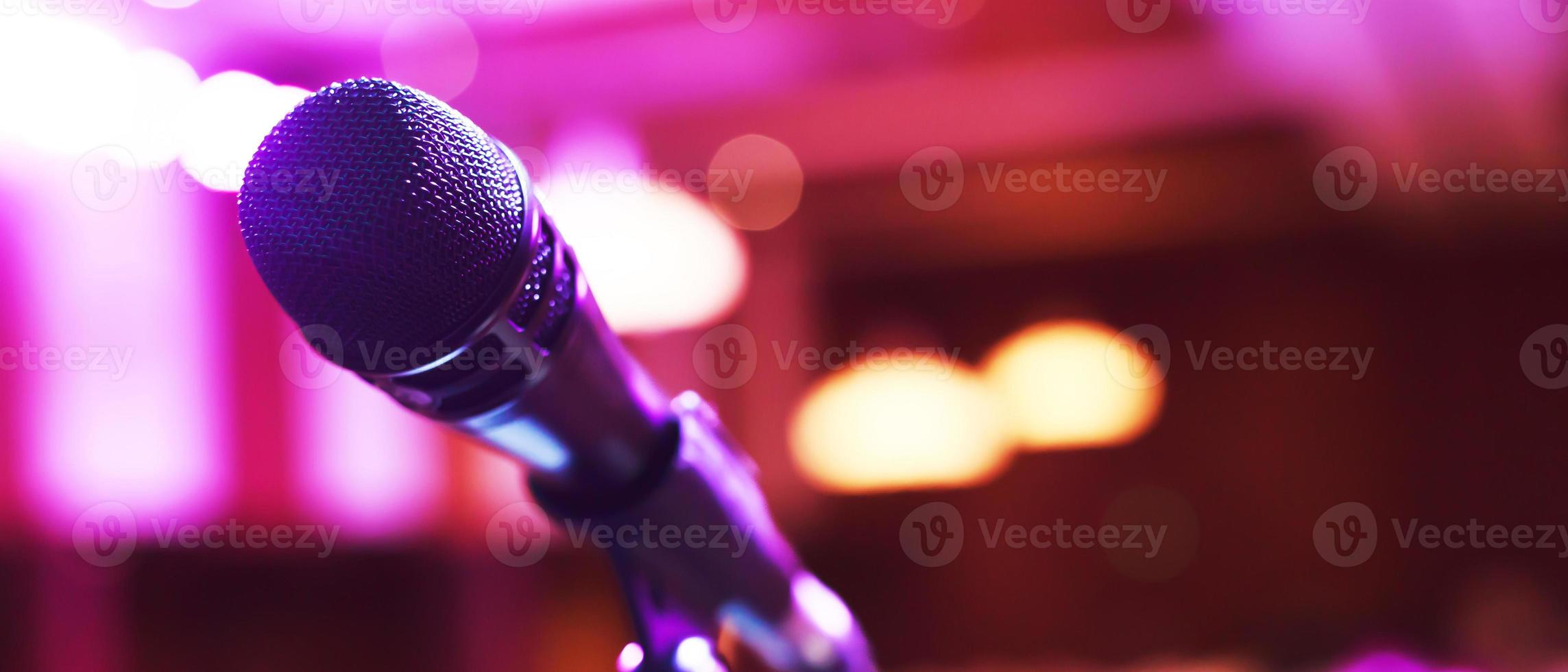 Close up of microphone on stage lighting at concert hall or conference room. copy space banner. soft focus. photo