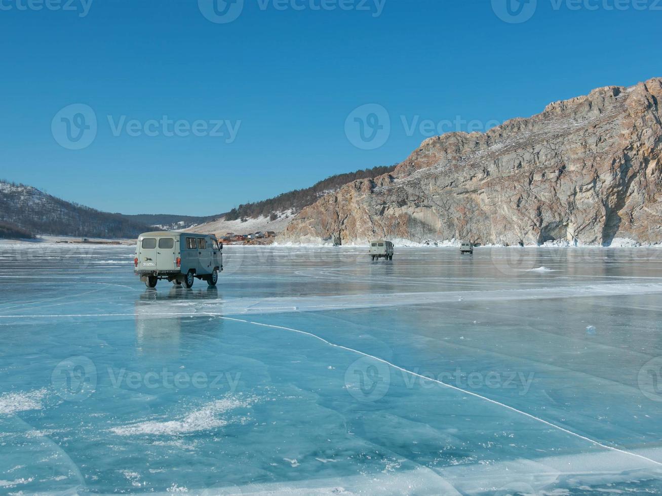 jeeps militares rusos, el transporte clásico lleva a los turistas a cruzar el hielo en el lago baikal en un viaje de invierno. foto