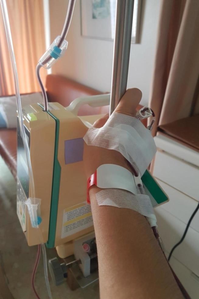 Blurred image of a patient hand with iv tube for blood transfusion. photo