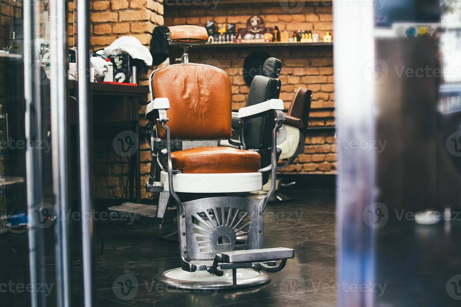 Stylish Vintage Barber Chair In brick wall Interior. Barbershop Theme. Barbershop armchair. Modern hairdresser and hair salon, barber shop for men. photo