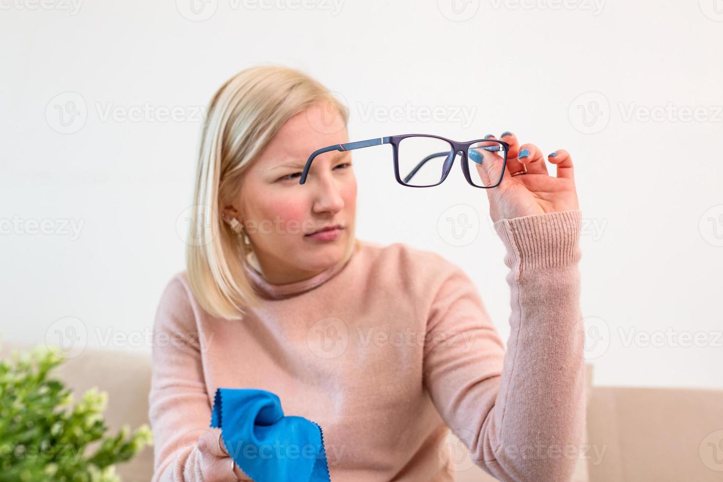 Woman cleaning reading glasses with cloth. Women hand cleaning glasses