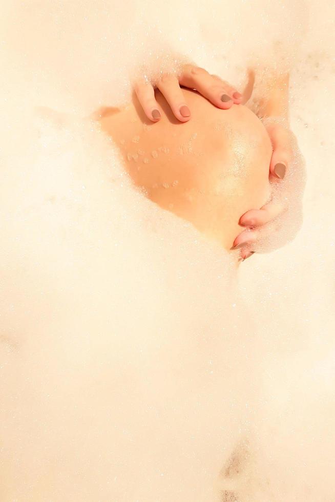 Hands and knee of lady on bubble foam background in sexy posturing. photo