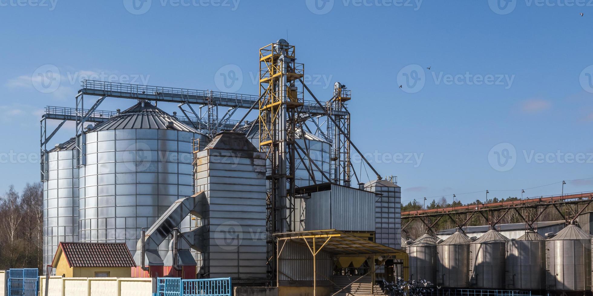 panorama view on agro silos granary elevator on agro-processing manufacturing plant for processing drying cleaning and storage of agricultural products, flour, cereals and grain. photo