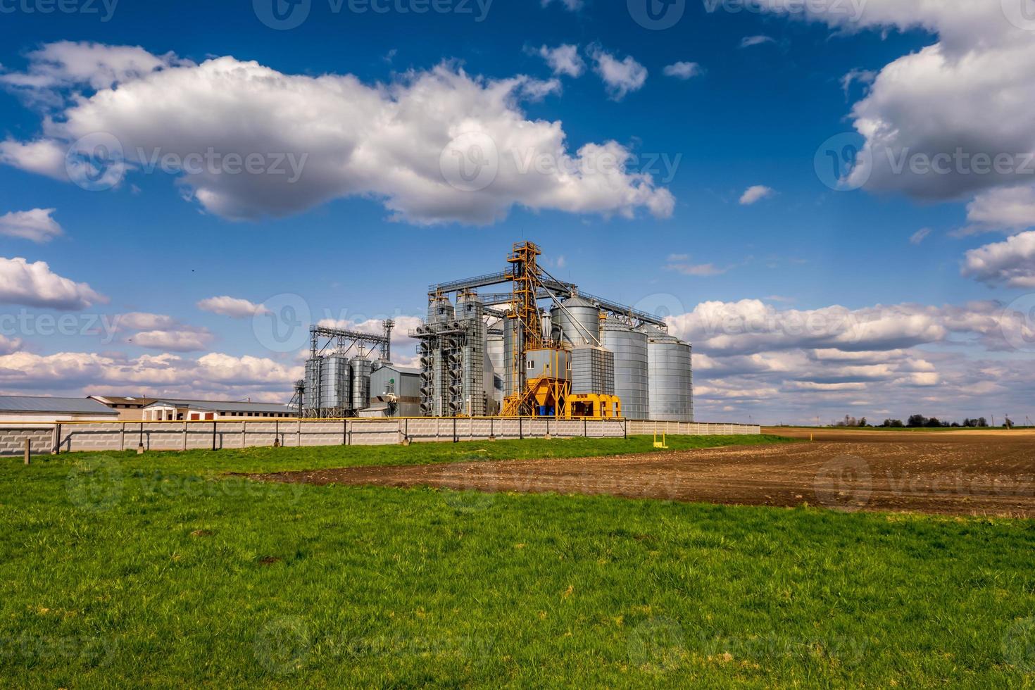 Modern Granary elevator. Silver silos on agro-processing and manufacturing plant for processing drying cleaning and storage of agricultural products, flour, cereals and grain. photo