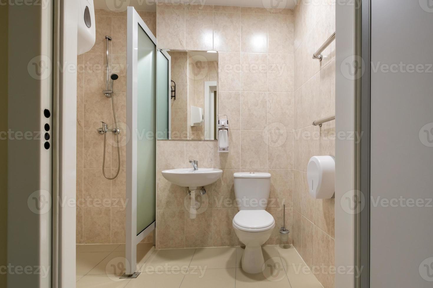 toilet and detail of a corner shower cabin with wall mount shower attachment photo