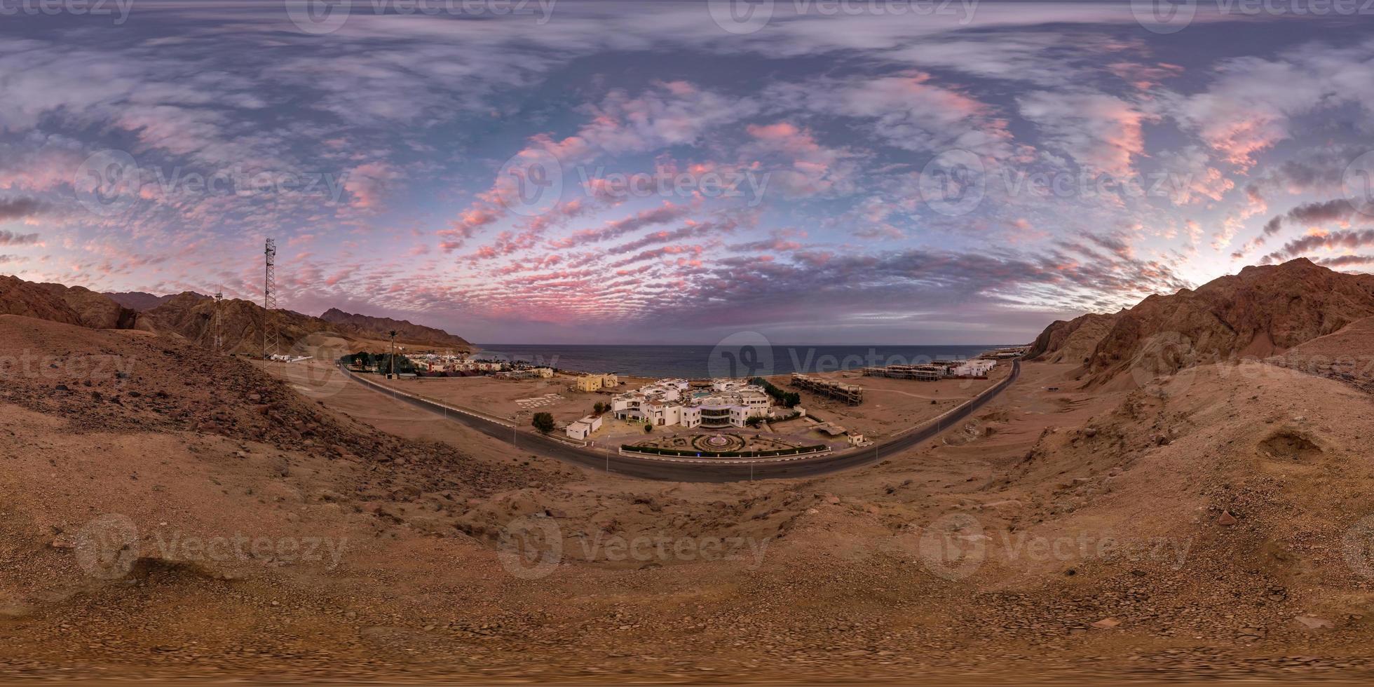 full seamless spherical hdri 360 panorama view of sunset on coast of sea high in sandy mountains with awesome clouds overlooking ancient oriental city in equirectangular projection, ready for VR AR photo