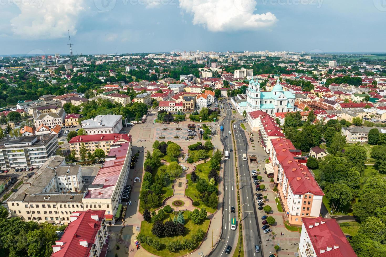 aerial panoramic view from great height on red roofs of old big city with skyscrapers and white fluffy clouds photo