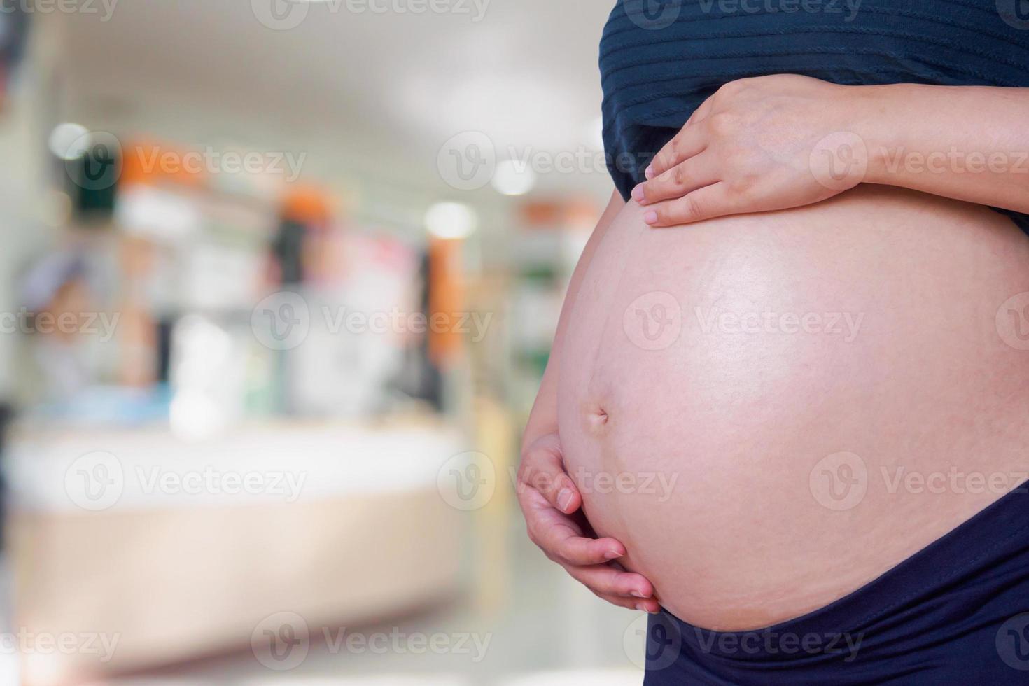 Pregnant woman with hospital blur background photo