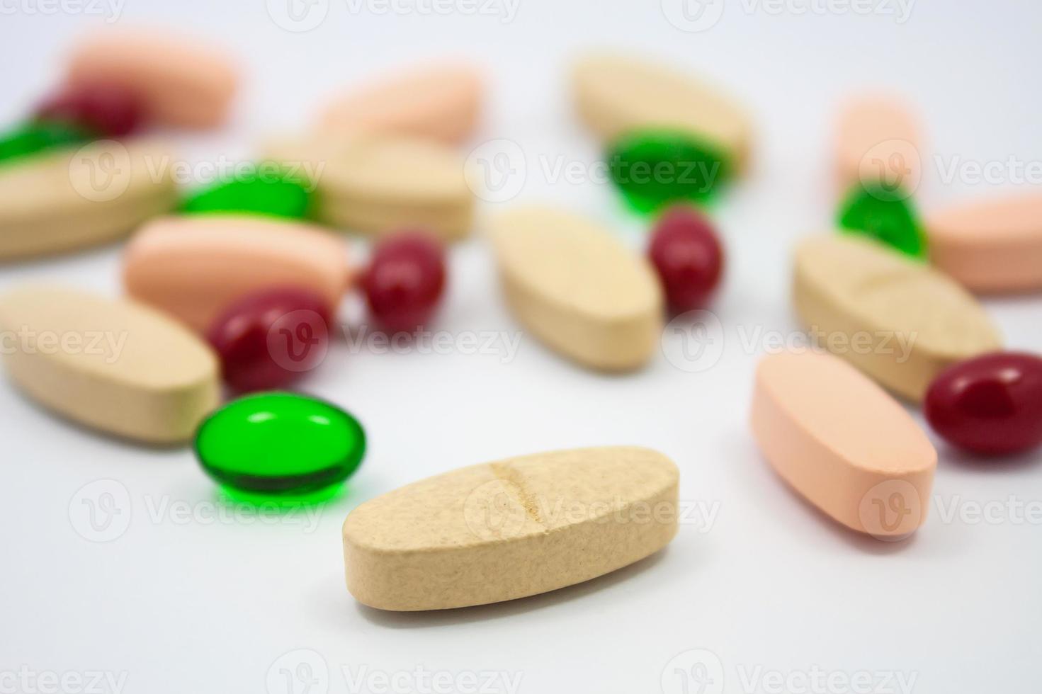 Colored pills, tablets and capsules on a white background photo