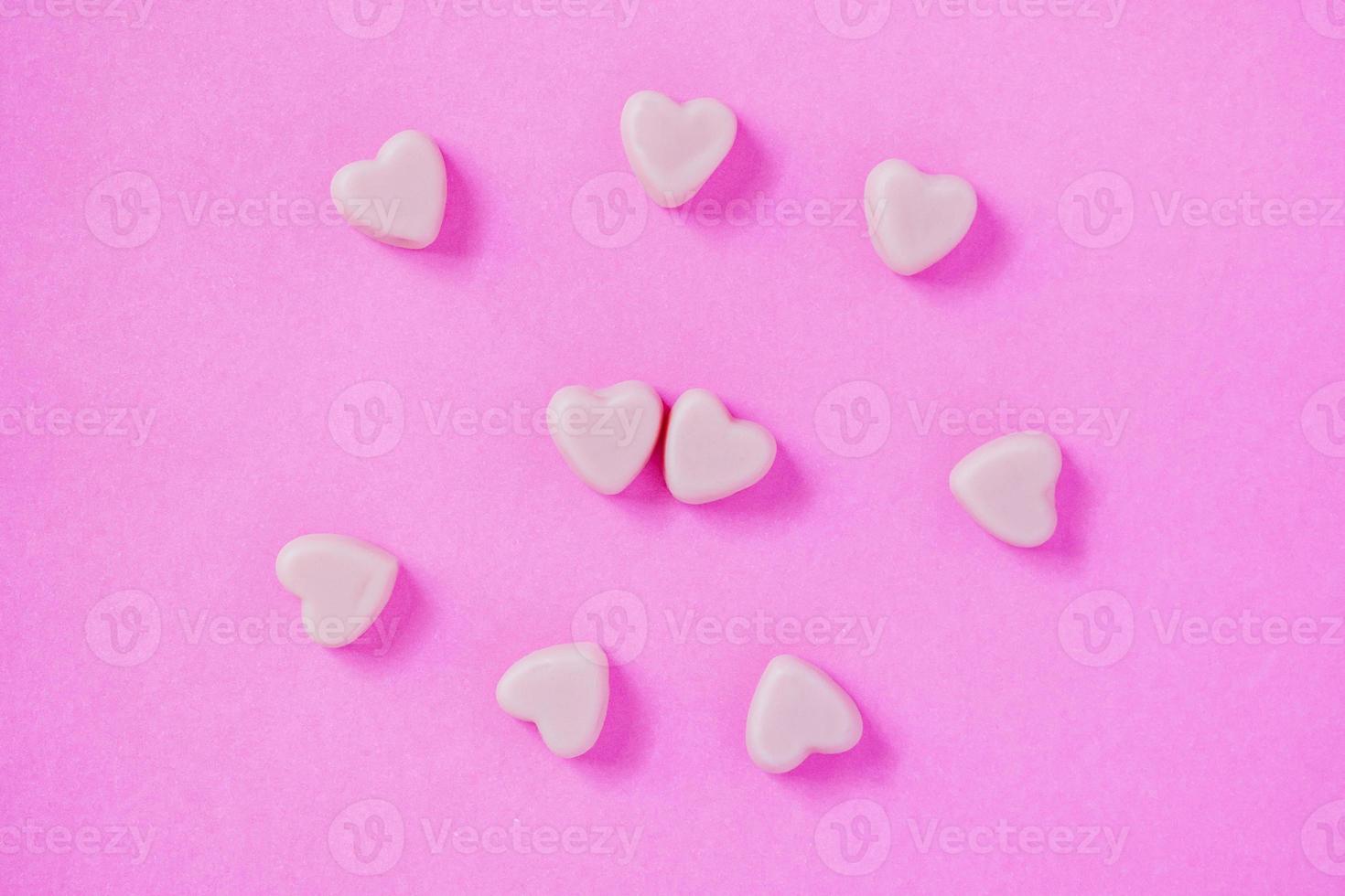 forma de corazones de caramelo de san valentín sobre fondo rosa foto