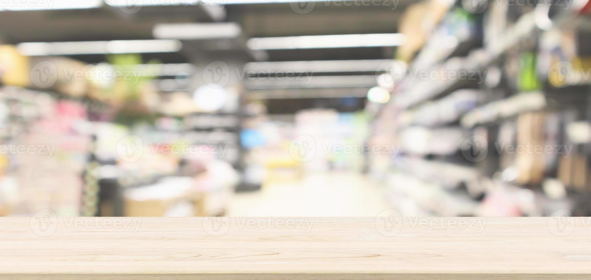 Wood table top with supermarket aisle blur background for product display photo