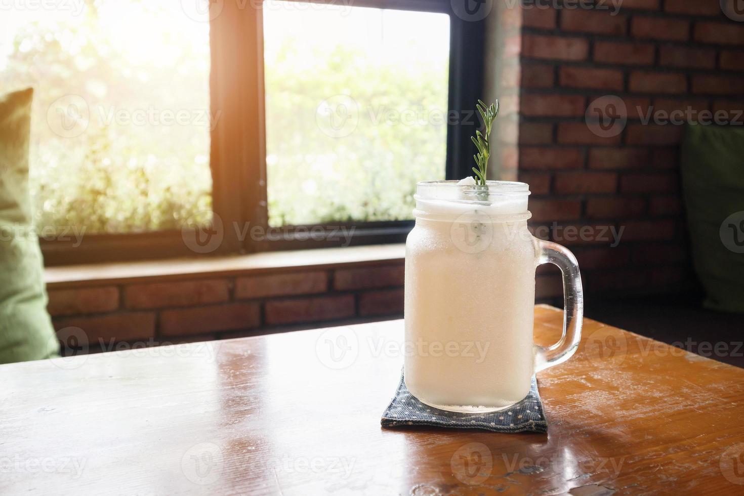 frappe de agua de coco con hojas de romero en la mesa del restaurante foto