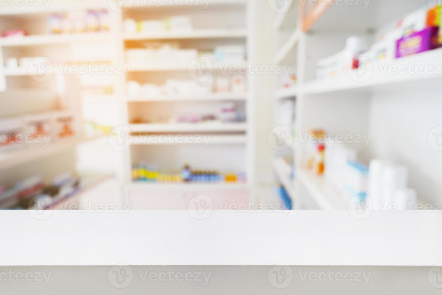 mostrador de madera con estantes borrosos de medicamentos en la farmacia foto