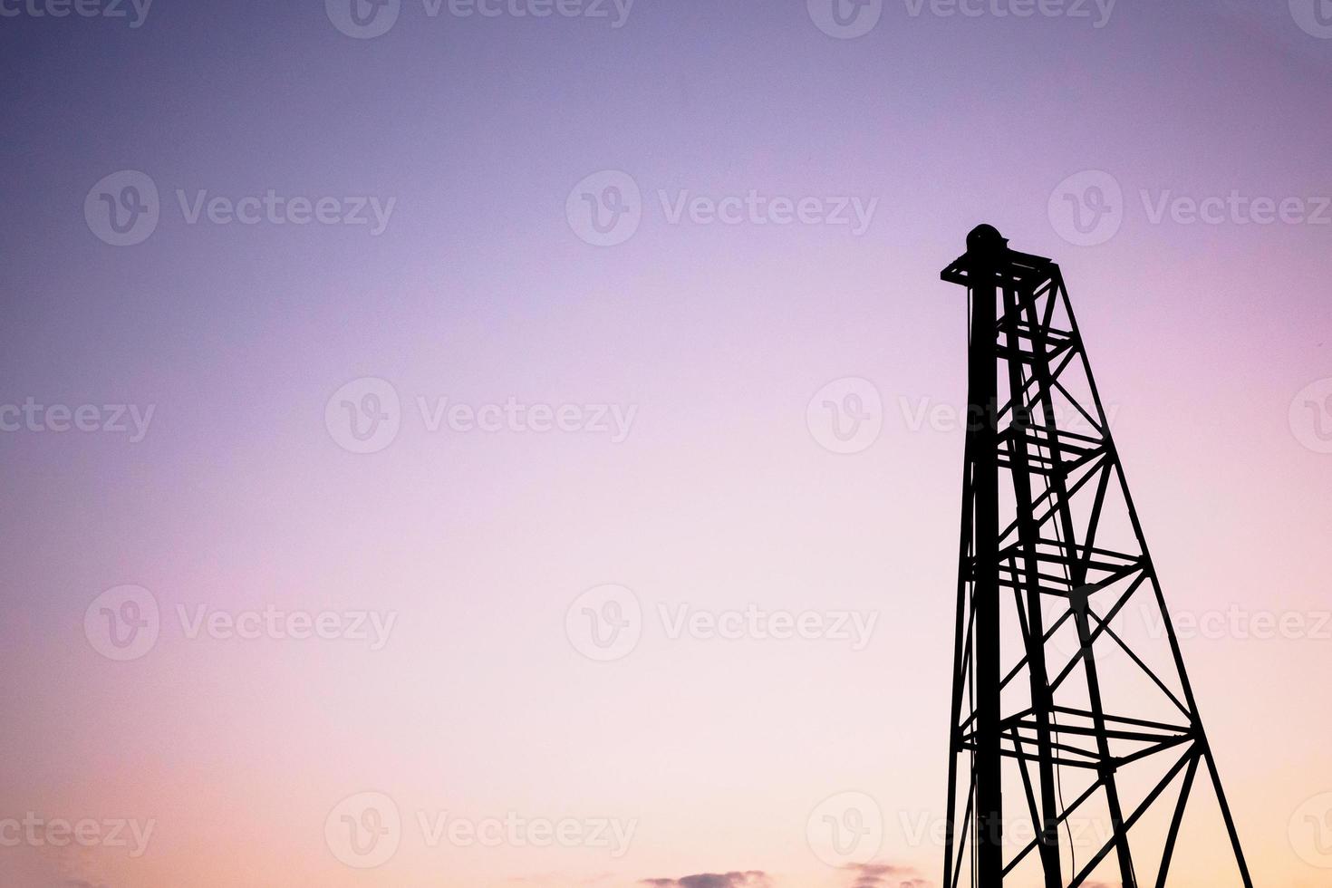 Silhouette pile driver at construction site photo