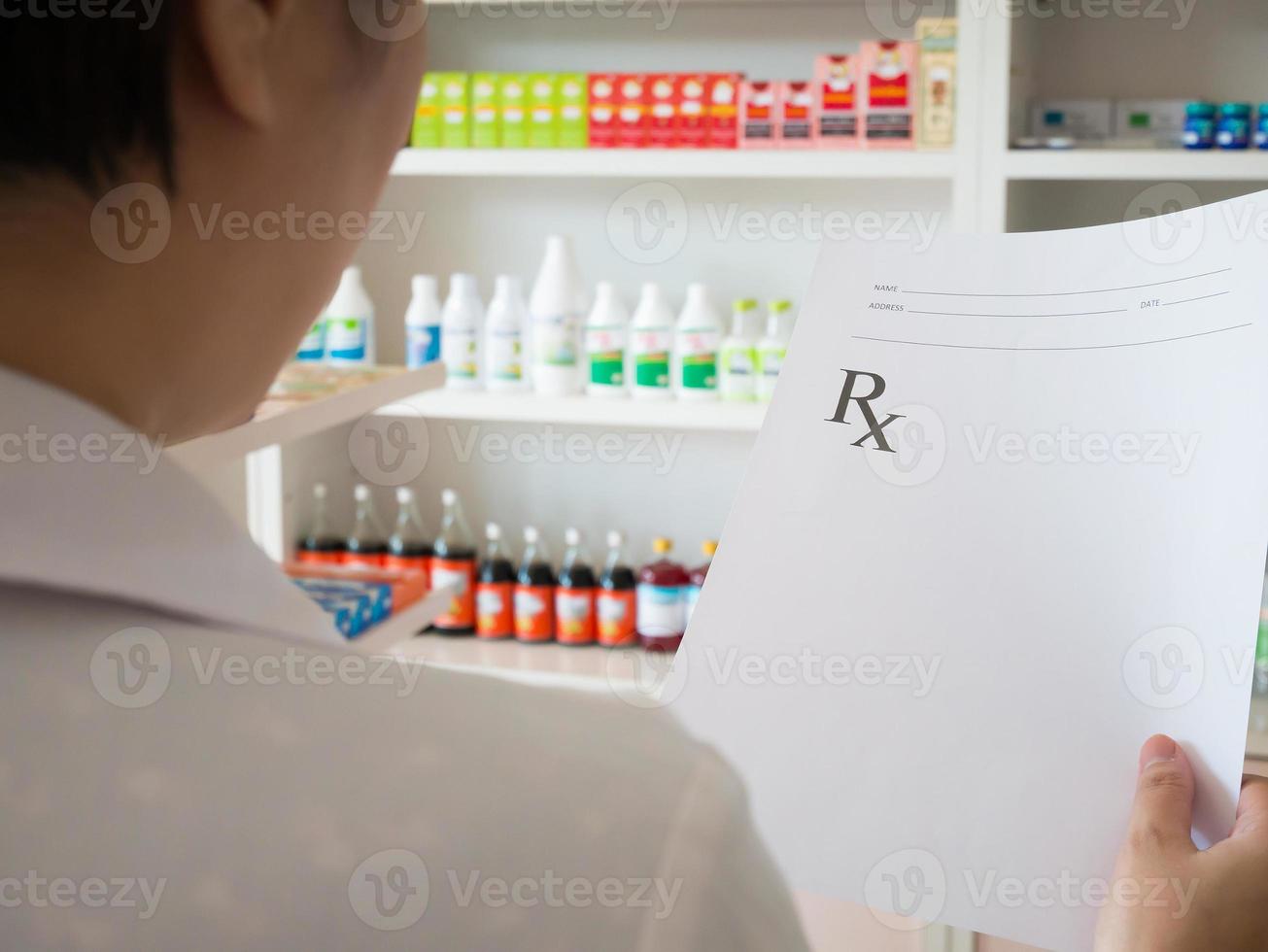 female pharmacist reading prescription at the pharmacy photo