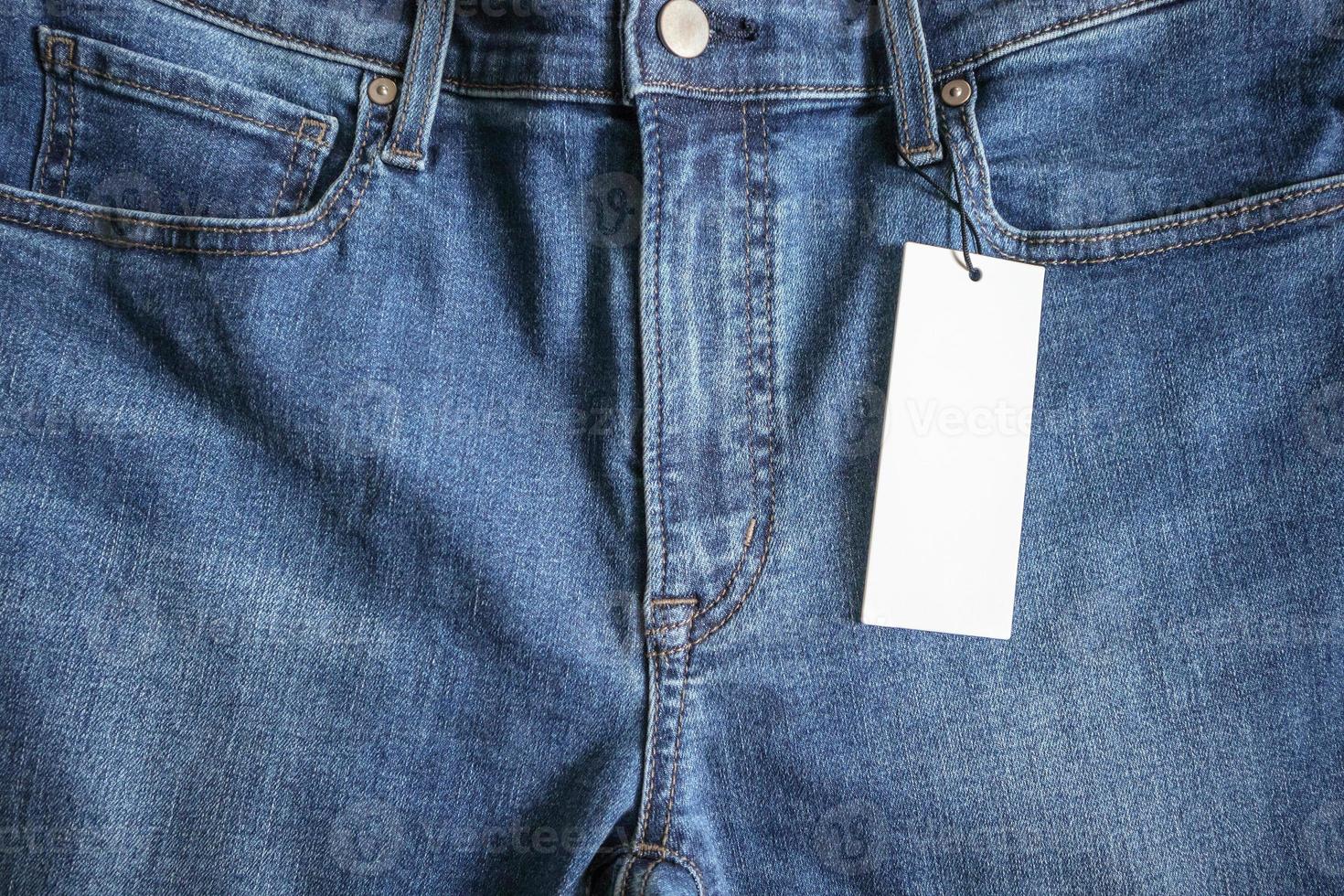 Blue jeans with blank white price label tag photo