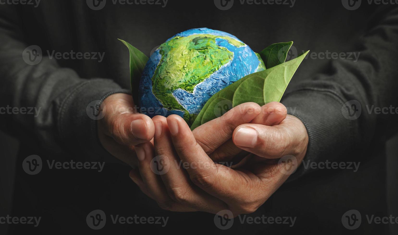 World Earth Day Concept. Green Energy, ESG, Renewable and Sustainable Resources. Environmental and Ecology Care. Hand Embracing Green Leaf and Handmade Globe photo