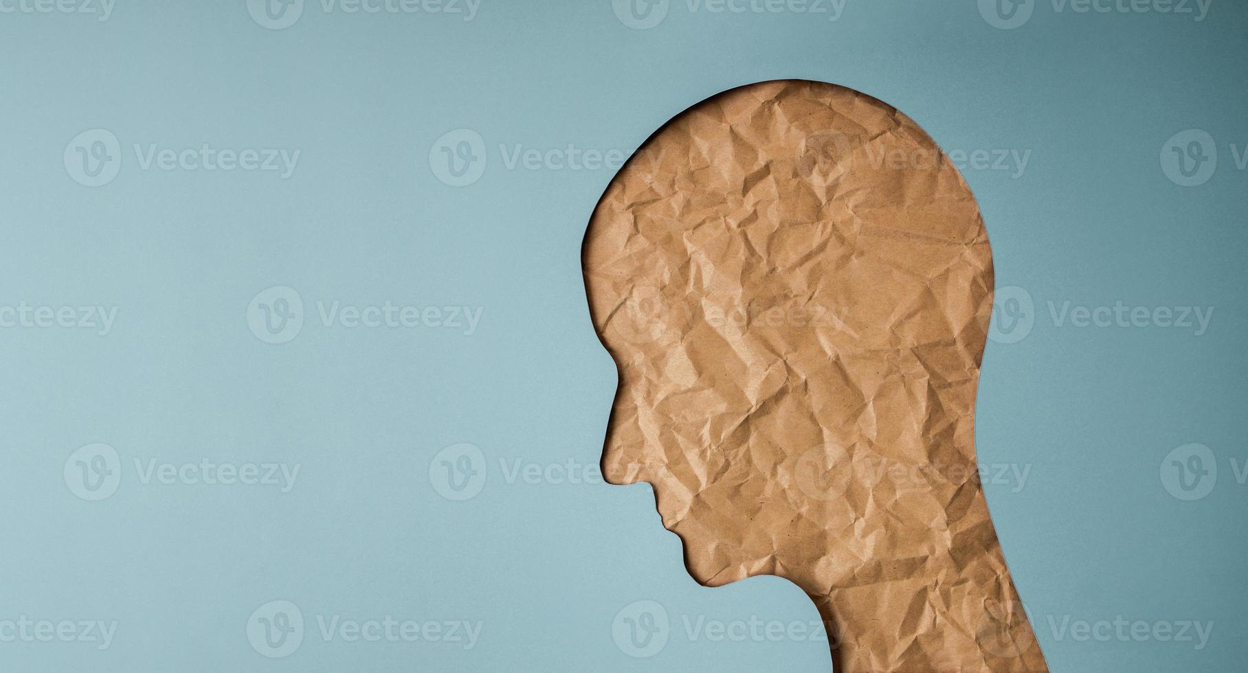 Aging Concept. Shape of Woman Head created by Crumpled Craft Paper Cut. Old Wrinkled Skin Lady. Sadness Female Face photo