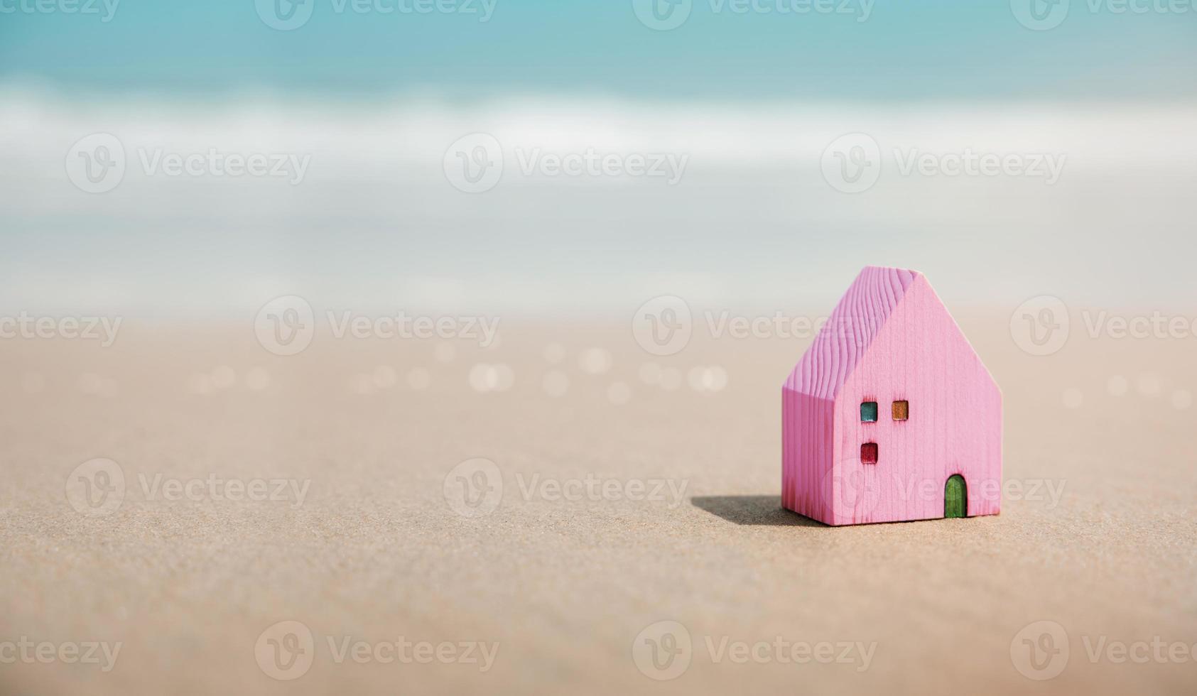 Beach House Concept. Mini Colorful Wooden House on the Sand Beach. Destination for Vacation or Retirement Life. Summer Sunny Day. Metaphor Photo