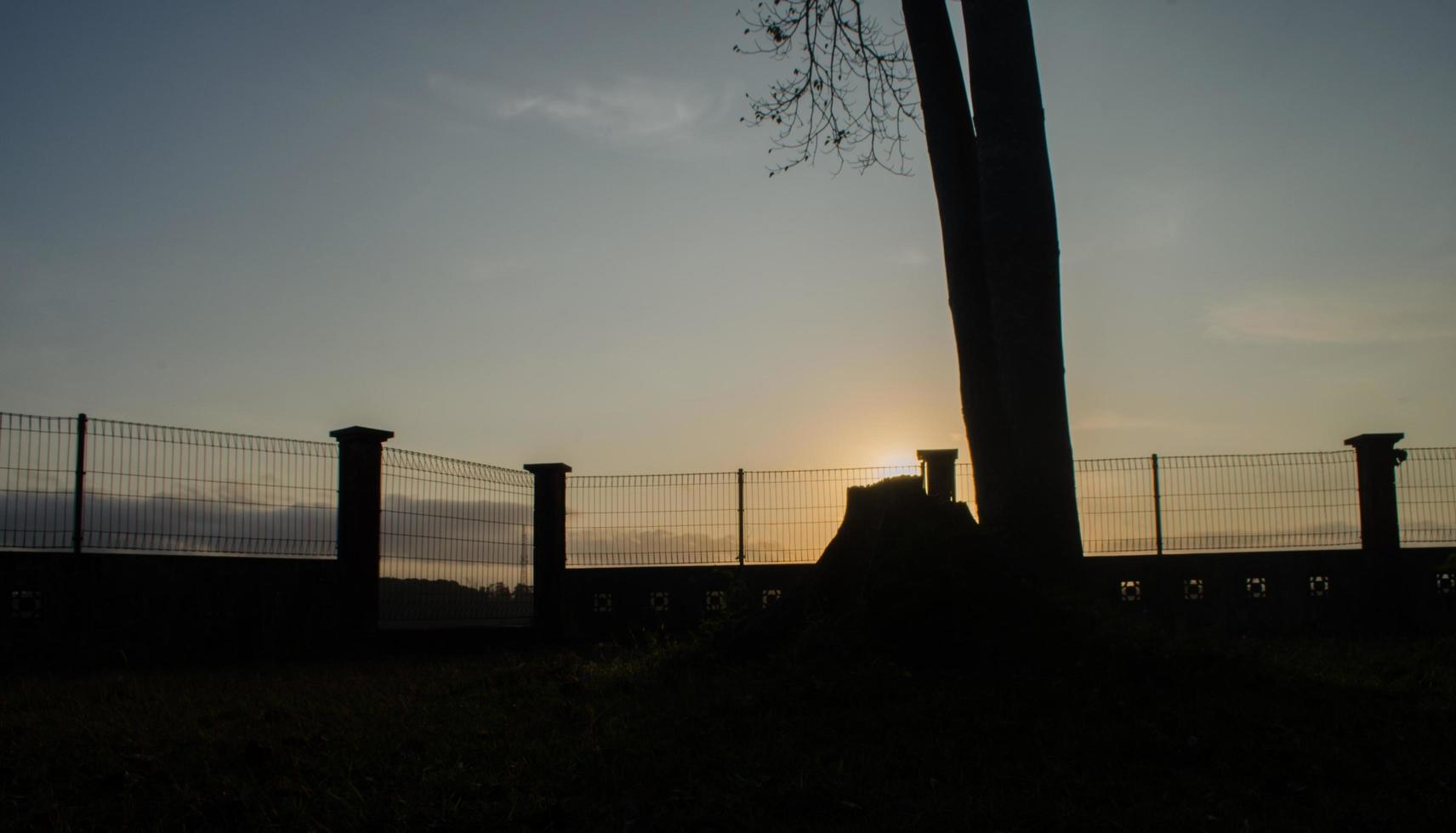 la silueta de la barandilla, árboles y piedras de espaldas al sol de la mañana. paisaje de silueta,vista amplia, panorámica foto