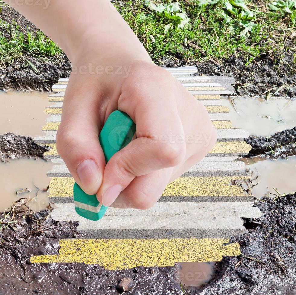 hand deletes wet road from image by rubber eraser photo