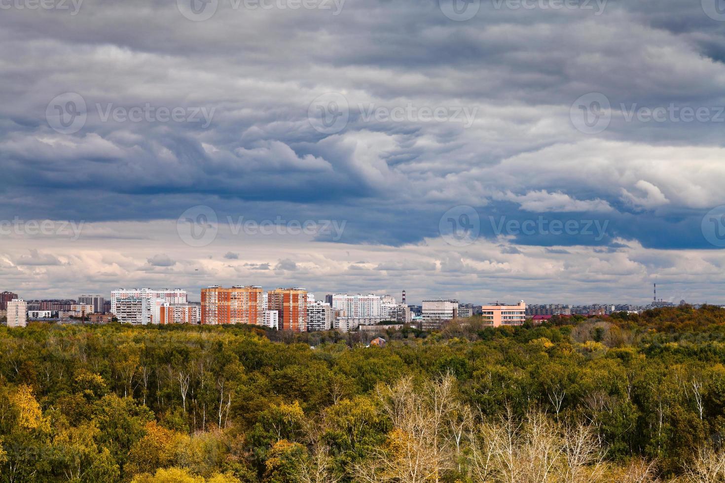 dark blue rainy clouds over city in autumn photo