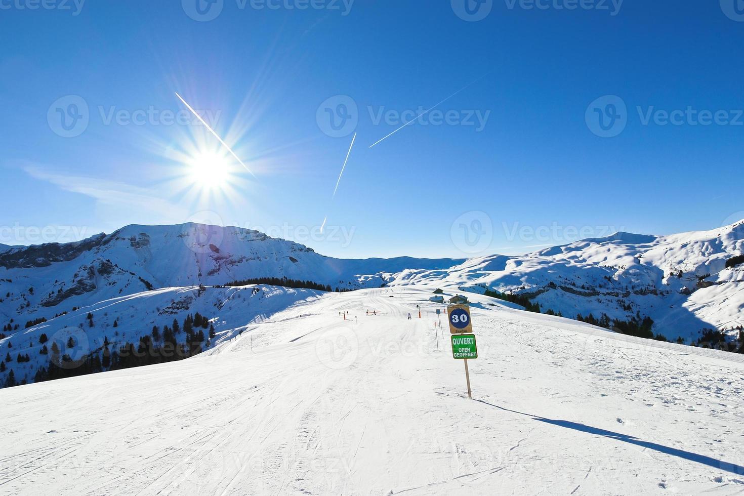 skiing tracks on snow slopes in sunny day photo